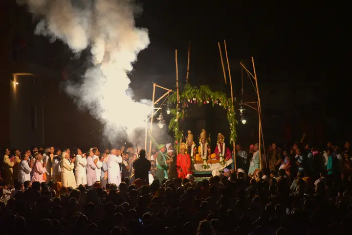 Night scene of the Ramnagar Ramlila with crowds around a lit stage