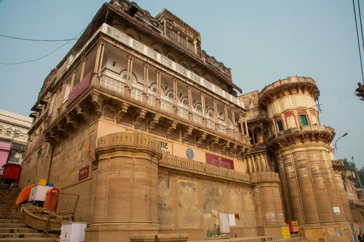 The sandstone Ganga Mahal palace rising above the steps just north of Assi Ghat, with arched balconies on its upper floors