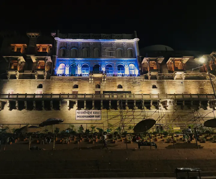 Man Mandir palace lit at night above Man Mandir Ghat